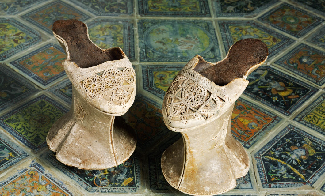 Perforated leather shoes on carved pine